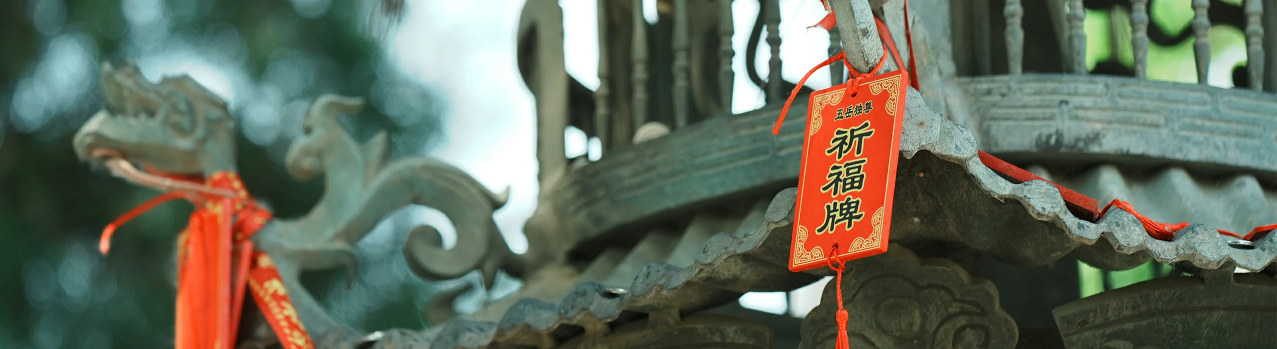 Bronze incense burner with red blessing ribbon in Taoist temple courtyard
