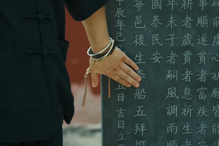 Wrist with bracelet near Taoist blessing inscription for spiritual bracelet service