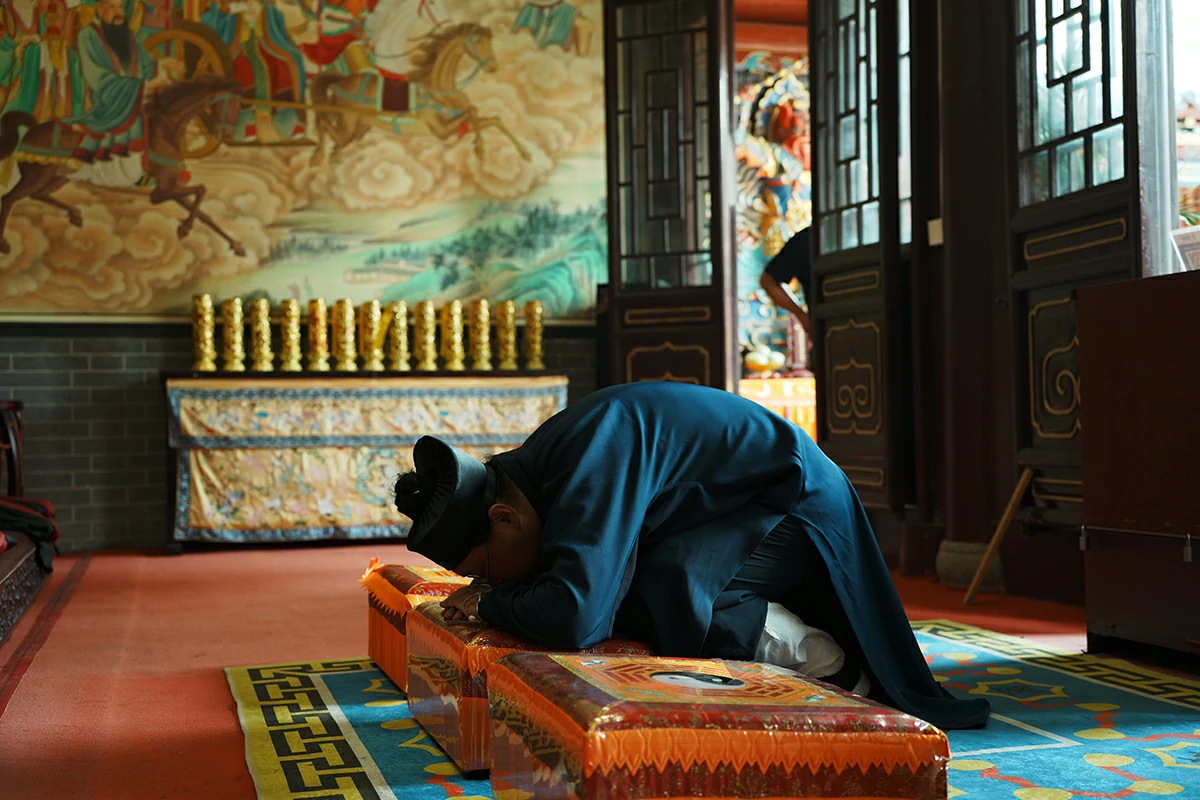 Taoist practitioner kneeling during temple blessing ceremony