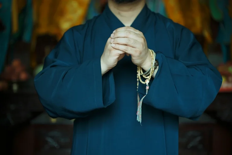 Taoist practitioner holding prayer beads for personal blessing ritual